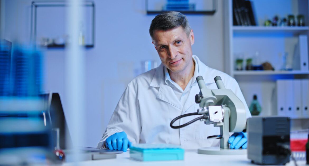 Confident man laboratory worker smiling on camera, scientist conducting research