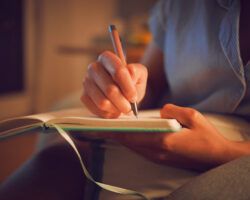 Creative writing at home by female hands enjoying a calm, peaceful day off indoors. Woman making notes in a journal, expressing her feelings and thoughts while making a note of a personal experience